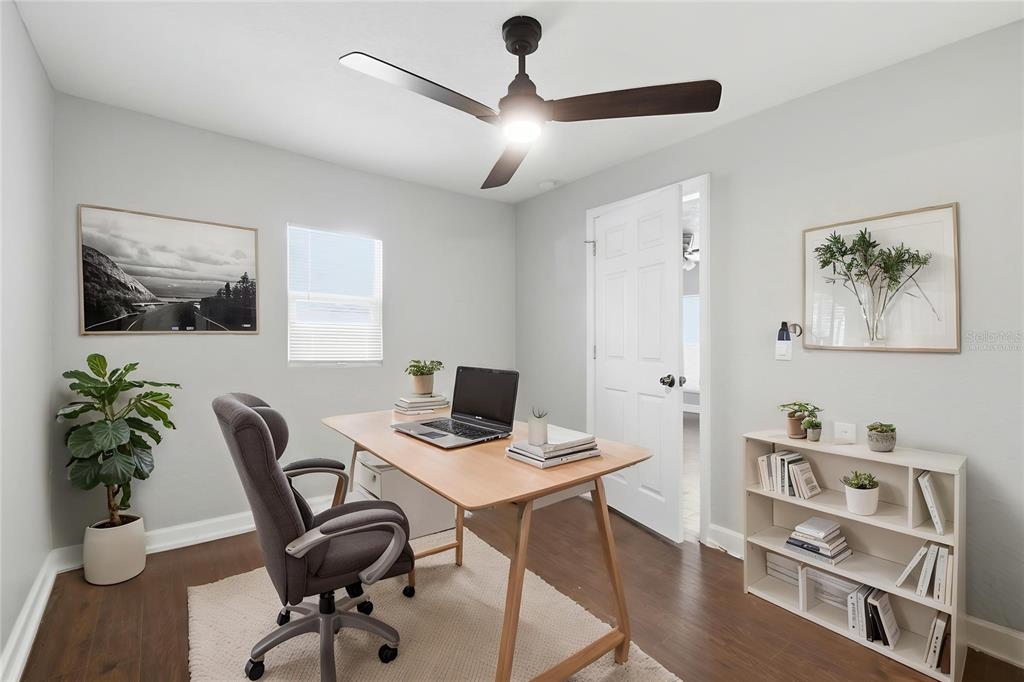 A home office with a wooden desk, gray chair, bookshelf, and ceiling fan — 1410 E WATERS AVENUE, TAMPA, FL