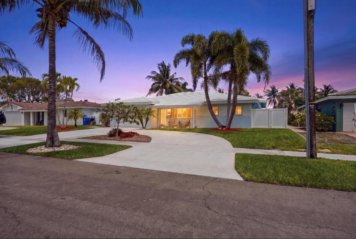 A single-story house with a light blue exterior, palm trees, and a concrete driveway — 380 SE 5th Avenue, Pompano Beach FL 33060, POMPANO BEACH, FL