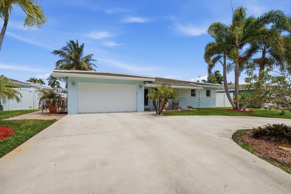 A light blue single-story house with a white garage door and palm trees in front — 380 SE 5th Avenue, Pompano Beach FL 33060, POMPANO BEACH, FL