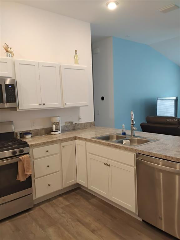 A kitchen with white cabinets, stainless steel appliances, and a light-colored countertop — 3561 COCHRAN STREET, THE VILLAGES, FL