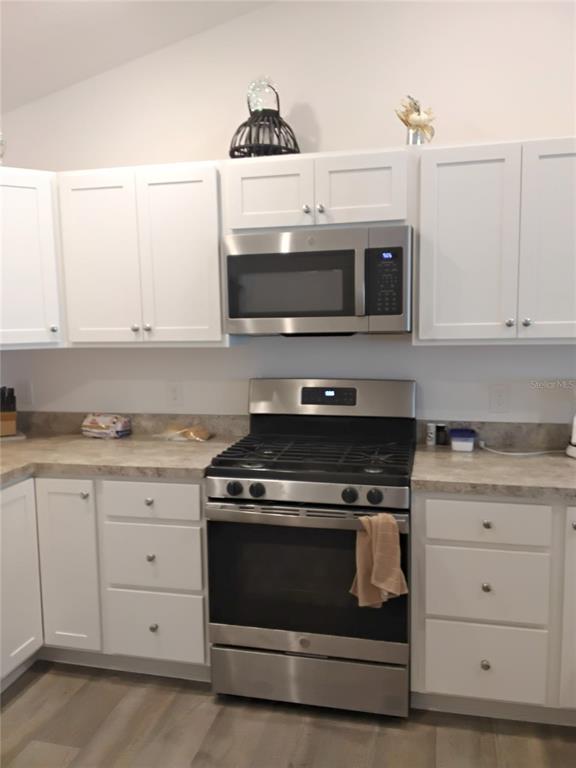 A kitchen features white cabinets, stainless steel appliances, and a laminate countertop — 3561 COCHRAN STREET, THE VILLAGES, FL