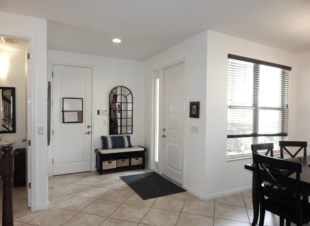 An entryway features a tiled floor, a storage bench with a mirror, and a front door — 4820 NW 16th Terrace, Boca Raton FL 33431, BOCA RATON, FL