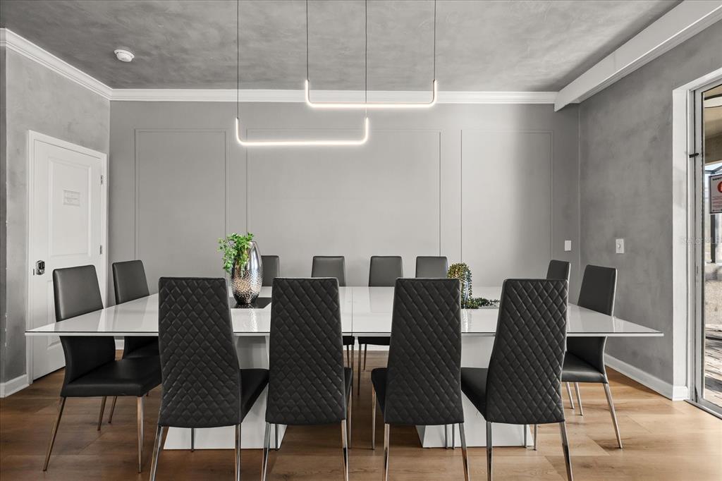 A dining room features a long white table, black chairs, and modern linear pendant lights — 4324 PROLOGUE WAY, KISSIMMEE, FL