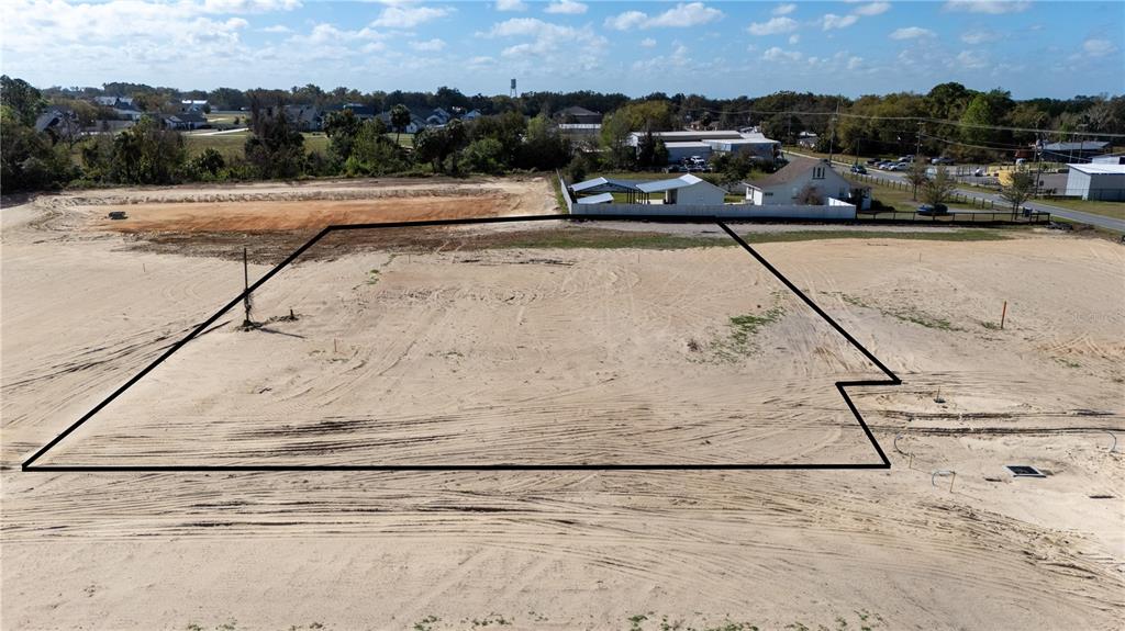 An aerial view shows a cleared, sandy residential lot outlined in black — 32792 DUNNE ROAD, SAN ANTONIO, FL
