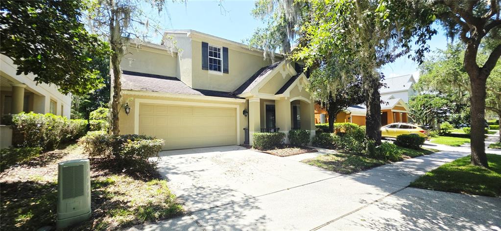 A two-story house with a beige stucco exterior, a two-car garage, and a concrete driveway — 230 W TARRINGTON DRIVE, DELAND, FL
