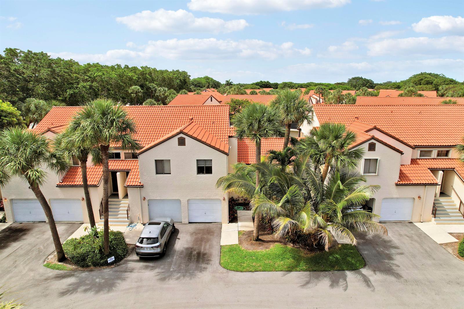 An aerial view of a multi-unit townhouse complex with orange tile roofs and palm trees — 11 Vía De Casas Sur, Boynton Beach FL 33426, BOYNTON BEACH, FL