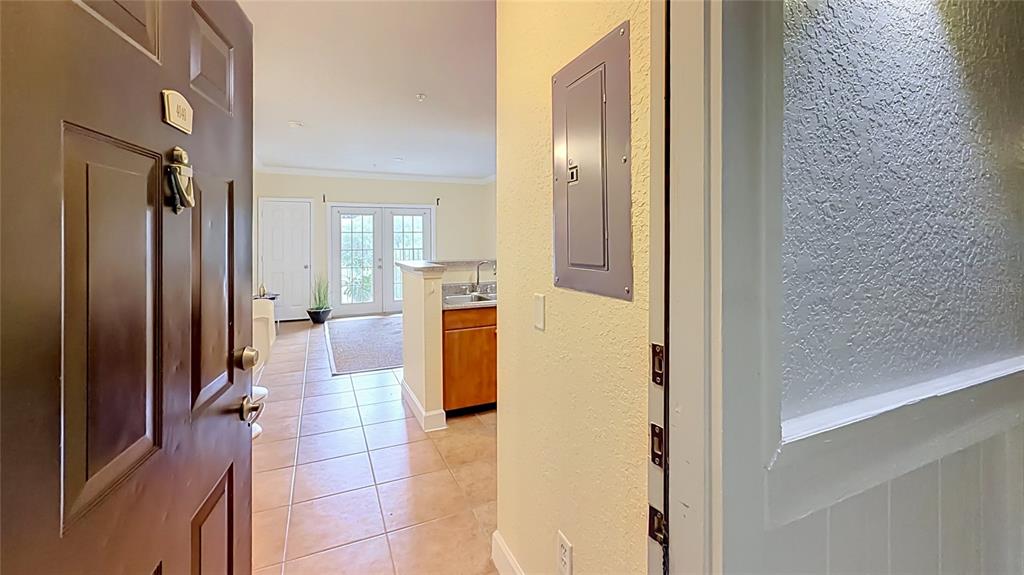A view from an open doorway into a tiled entryway, kitchen, and living area — 202 E SOUTH STREET UNIT 4040, ORLANDO, FL