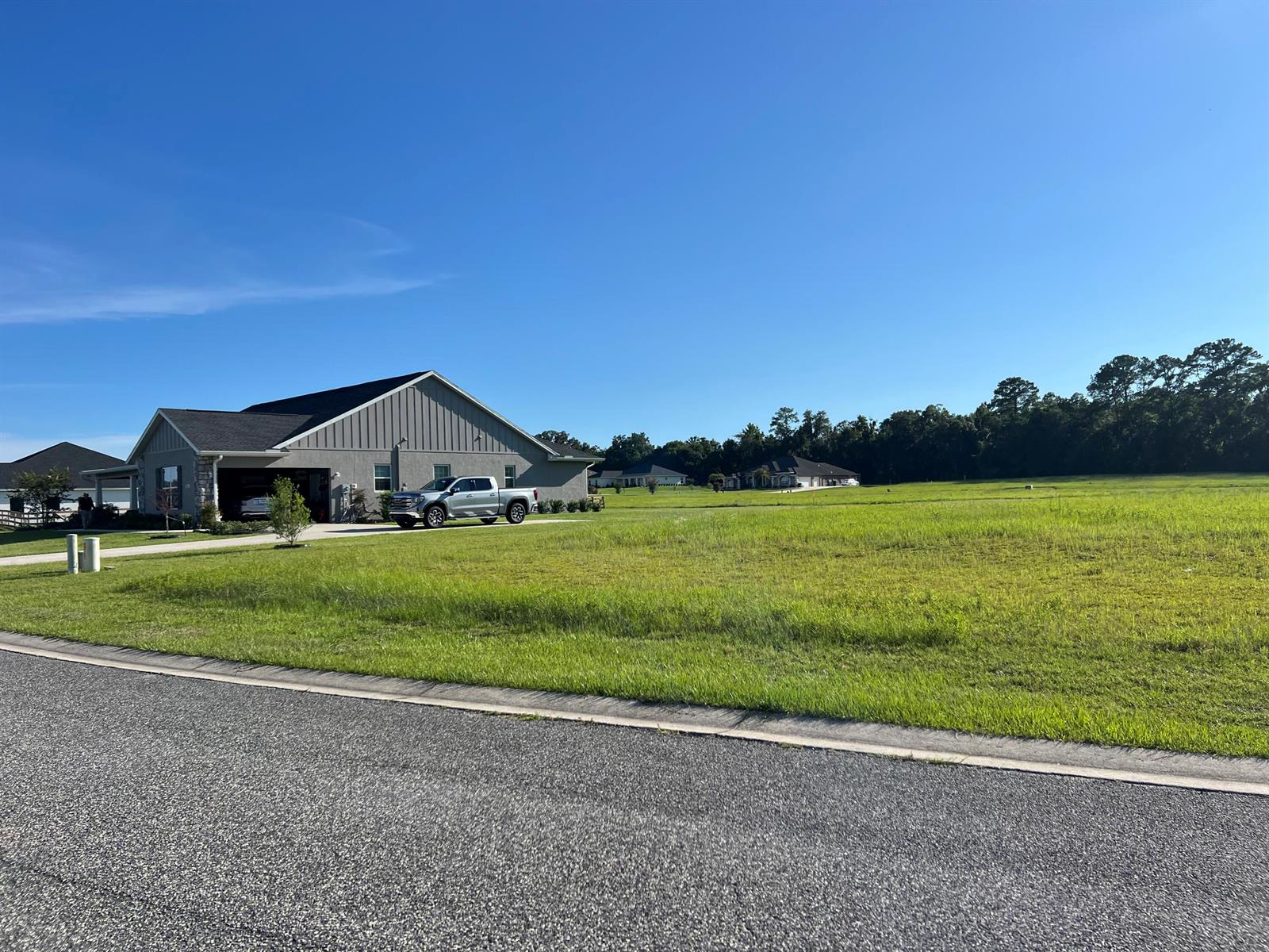 A gray house with a garage and a pickup truck sits beside a large lot — 000 NW 79th Loop, Ocala FL 34475, OCALA, FL