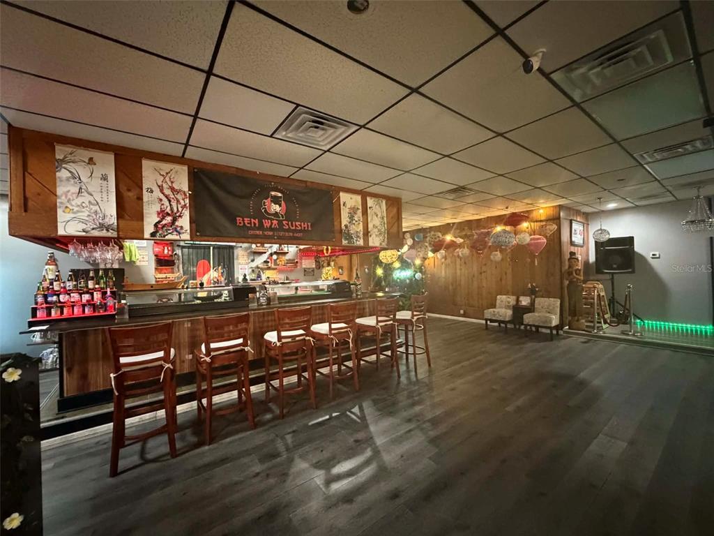 A sushi restaurant interior features a wooden bar with stools, hanging lanterns, and wood-paneled walls — 8256 ULMERTON ROAD, LARGO, FL