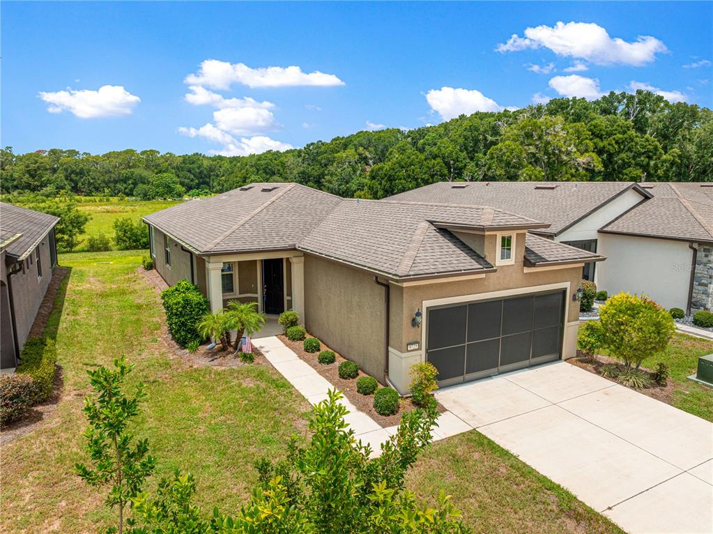 An aerial view of a single-story suburban house with a tan stucco exterior and garage — 9725 SW 63RD LOOP, OCALA, FL
