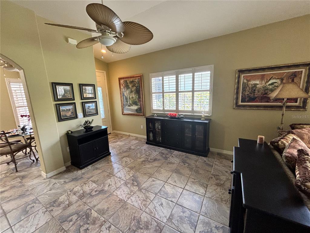 A living room with tile flooring, a ceiling fan, and dark wood furniture — 310 RECLINATA CIRCLE, VENICE, FL