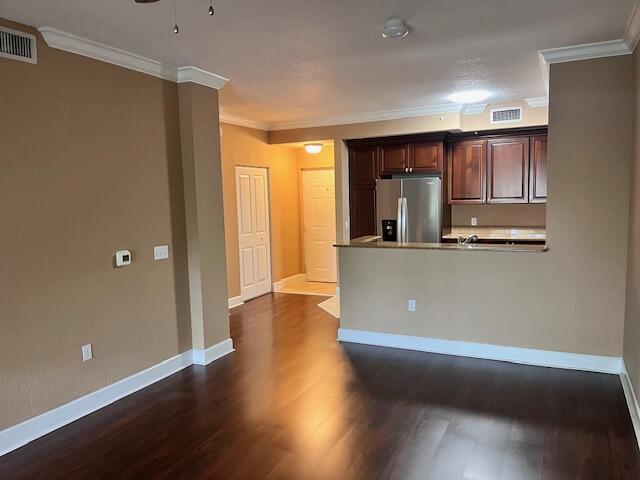An interior view shows a living area with dark wood floors, tan walls, and a kitchen — 4 Renaissance Way # 302, Boynton Beach FL 33426, BOYNTON BEACH, FL