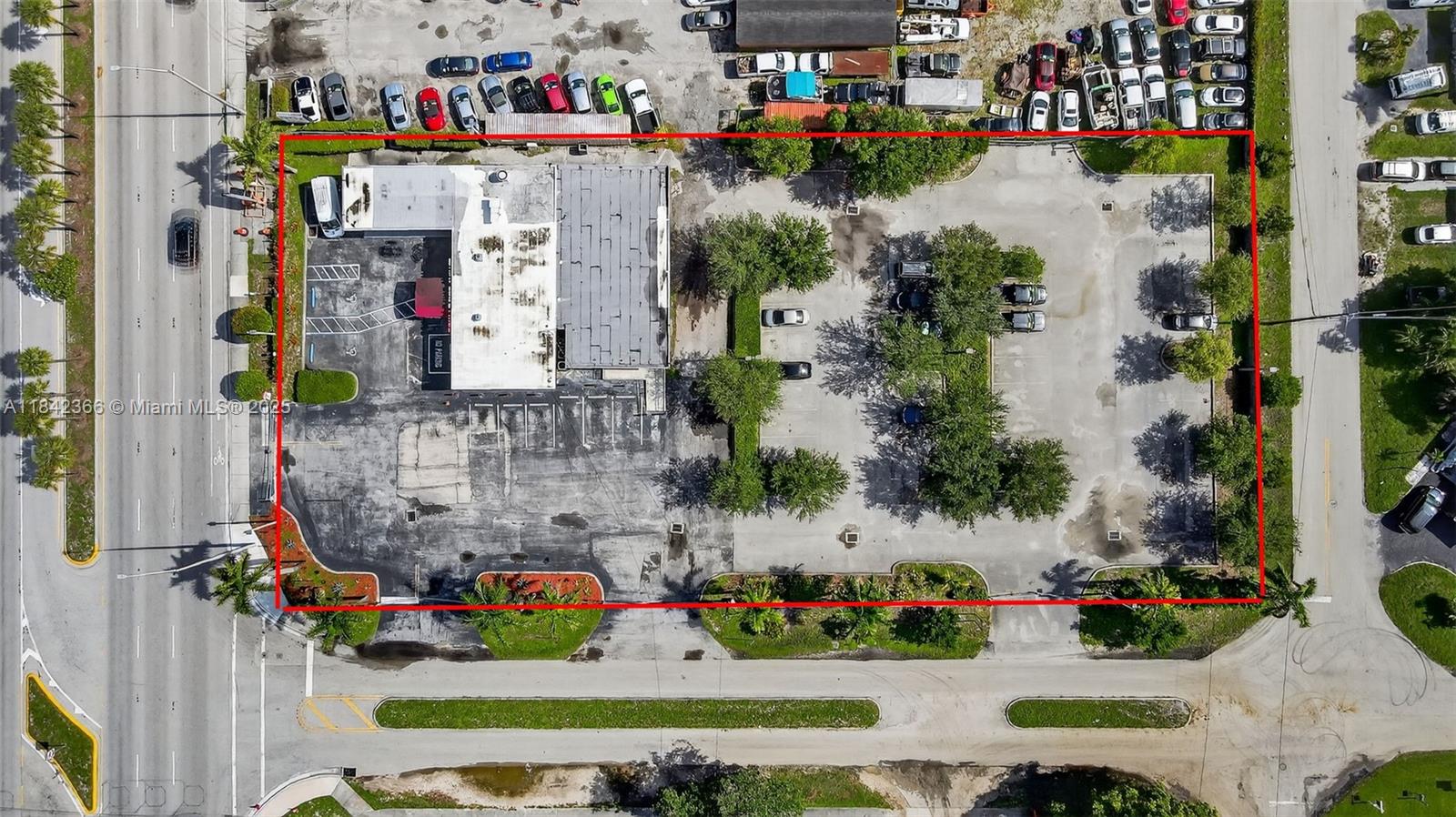 This aerial view shows a commercial building with a large parking lot outlined in red — 4950 S State Road 7, Hollywood FL 33314, HOLLYWOOD, FL