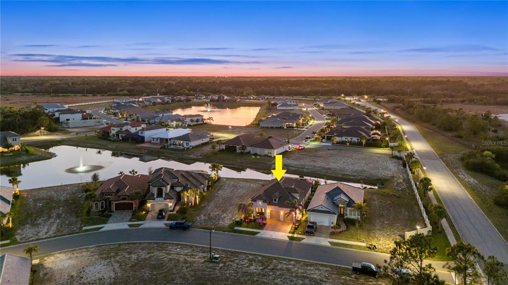 An aerial view shows a suburban house with a yellow arrow pointing to its roof — 5 RIO VISTA DRIVE, PALM COAST, FL