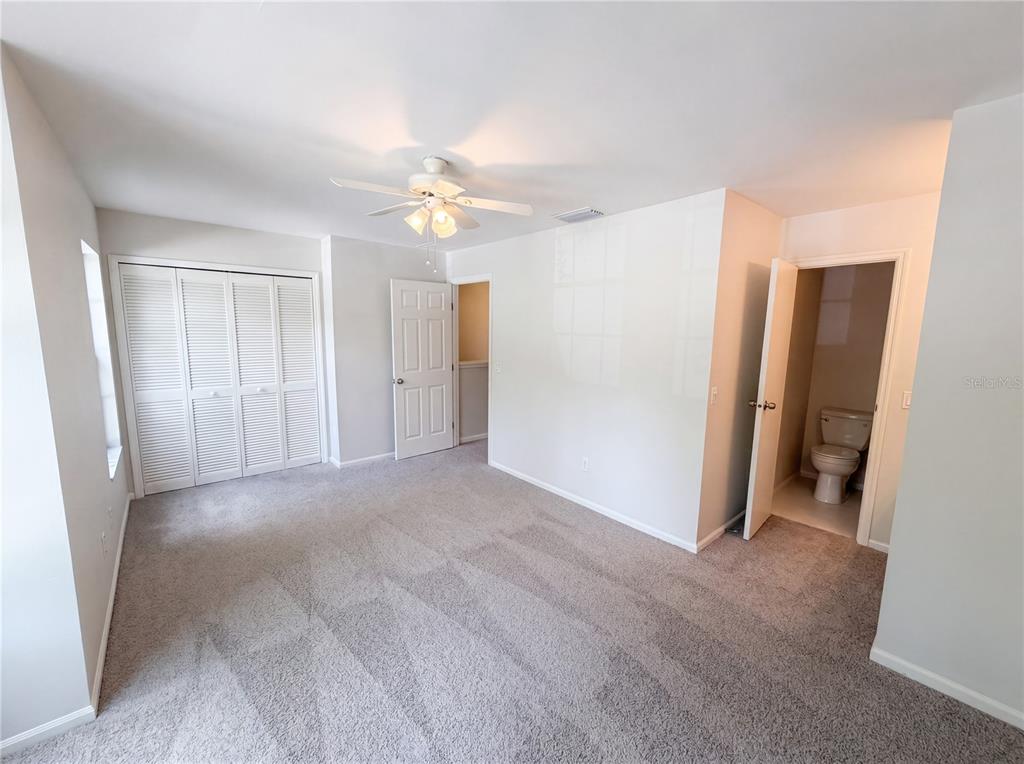 A bedroom with gray carpet, a ceiling fan, a closet, and an attached bathroom — 510 GREEN SPRING CIRCLE, WINTER SPRINGS, FL