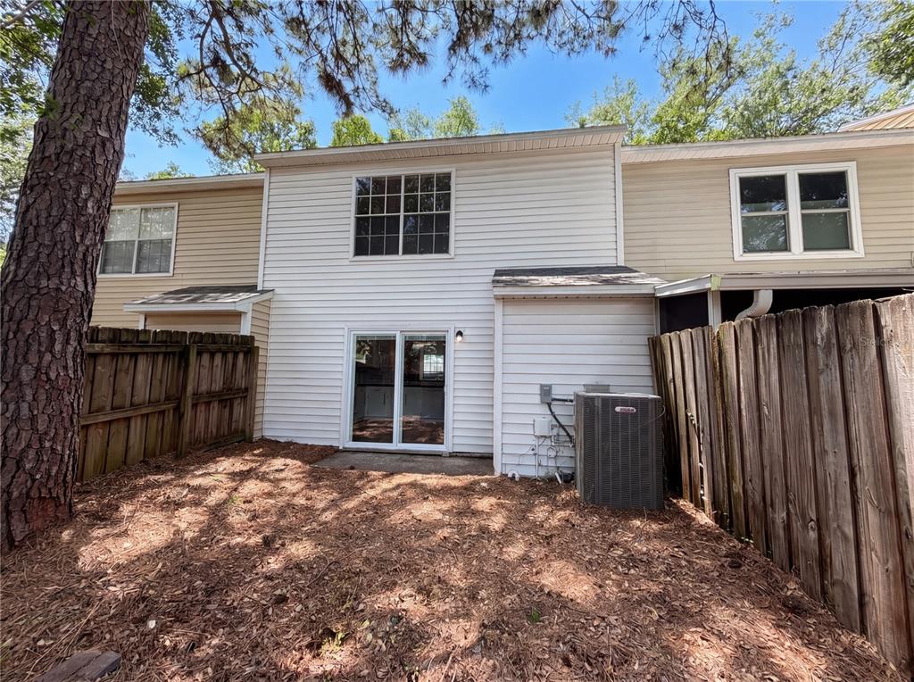 The exterior of a two-story townhouse features white siding, a sliding glass door, and an AC unit — 510 GREEN SPRING CIRCLE, WINTER SPRINGS, FL