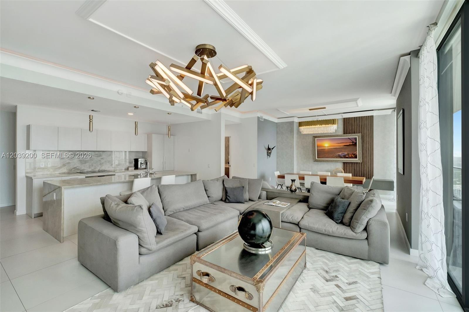 A modern open-concept living and dining area features a large sectional sofa and unique chandelier — 501 NE 31st St, Miami FL 33137, MIAMI, FL