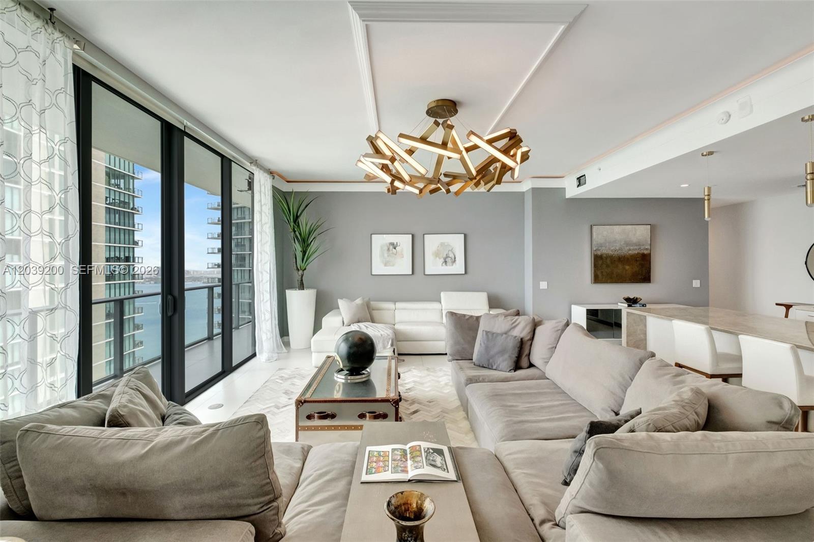 A living room features a large sectional sofa, a modern chandelier, and floor-to-ceiling windows — 501 NE 31st St, Miami FL 33137, MIAMI, FL