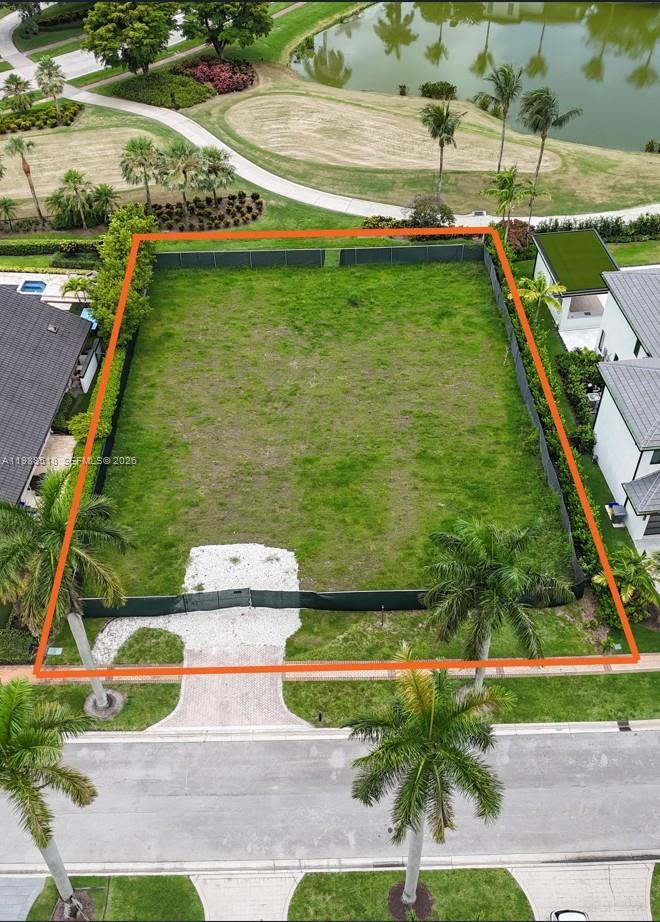An aerial view shows a vacant, fenced residential lot situated between two houses near a lake — 17591 Scarsdale Way, Boca Raton FL 33496, BOCA RATON, FL