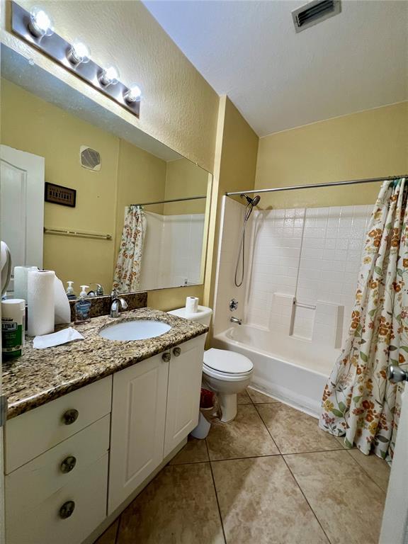 A bathroom features a granite vanity, white cabinets, a toilet, and a shower-tub combination — 2713 VIA MURANO UNIT 232, CLEARWATER, FL