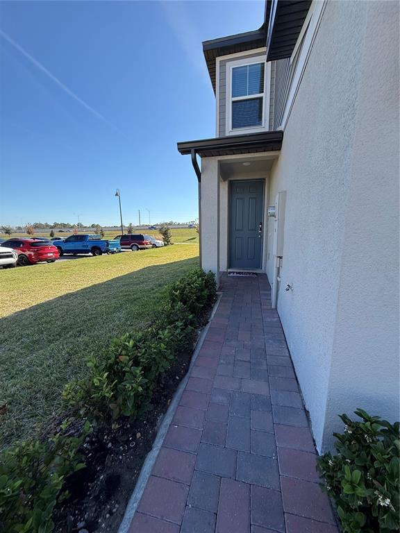 A paved walkway leads to the front entrance of a two-story stucco home — 2130 CRAPE JASMINE LANE, ORLANDO, FL