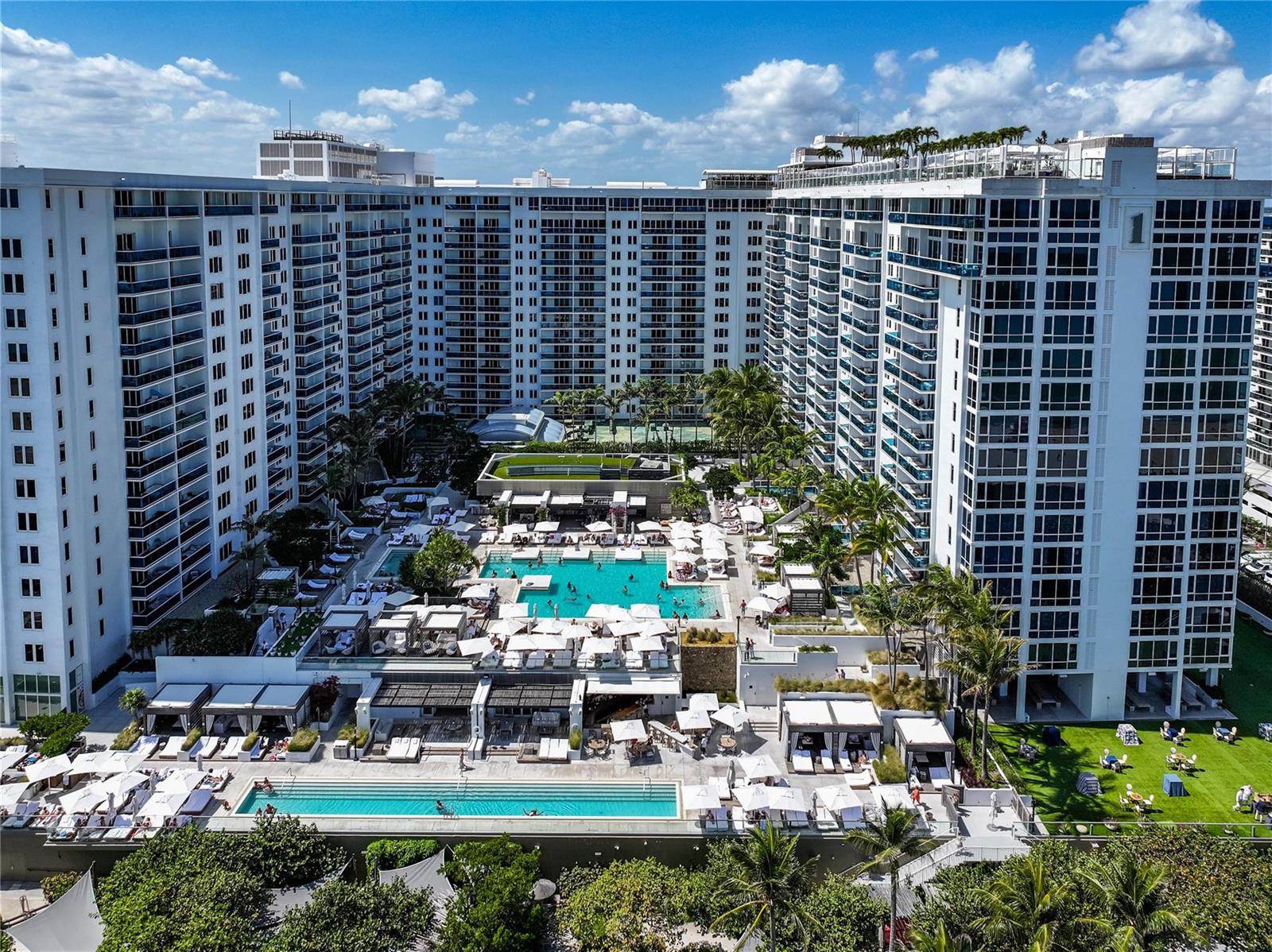 An aerial view of a large resort complex featuring multiple swimming pools and lounge areas — 2301 Collins Avenue # 1015, Miami Beach FL 33139, MIAMI BEACH, FL