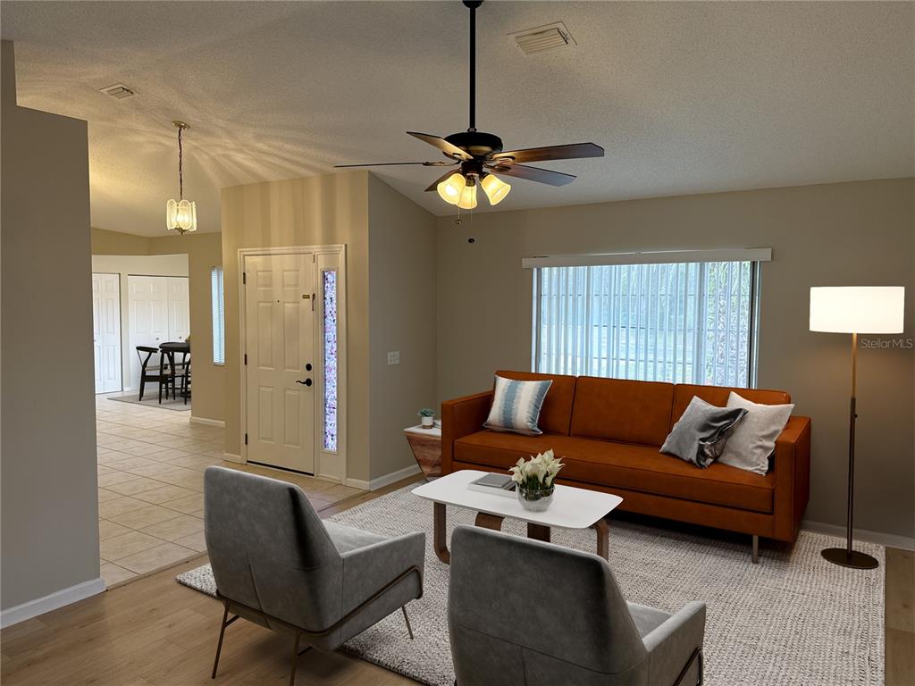 A living room features a brown sofa, two grey chairs, and a ceiling fan — 1988 NW 50TH AVENUE, OCALA, FL
