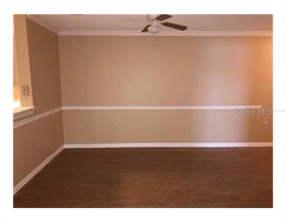 A room with tan walls, white chair rail molding, and dark wood-look flooring — 1909 SUMMER CLUB APT 115 DRIVE UNIT 115, OVIEDO, FL