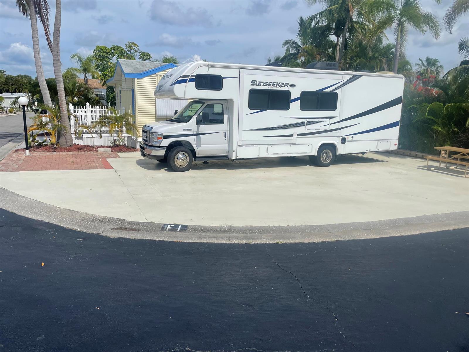 A white Sunseeker motorhome is parked on a concrete pad next to a small house — 900 Juno Ocean Walk F1, Juno Beach FL 33408, JUNO BEACH, FL