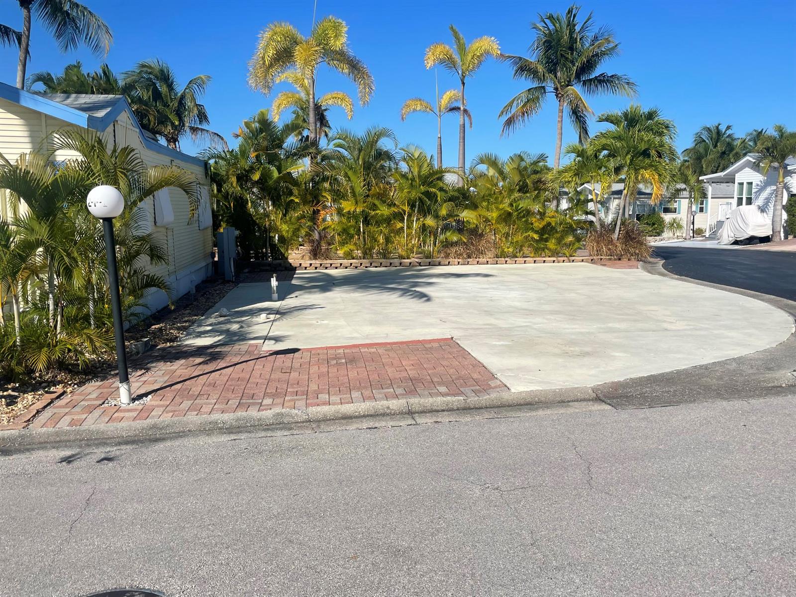A paved lot with a brick section sits next to a mobile home and palms — 900 Juno Ocean Walk F1, Juno Beach FL 33408, JUNO BEACH, FL
