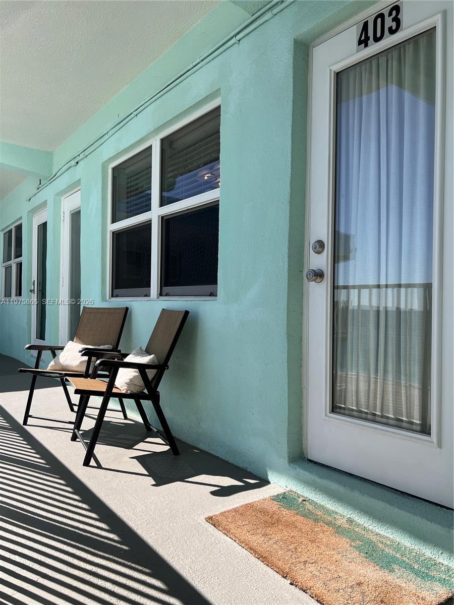 A balcony with two chairs, a door labeled 403, and teal exterior walls — 2600 N Surf Rd # 403, Hollywood FL 33019, HOLLYWOOD, FL