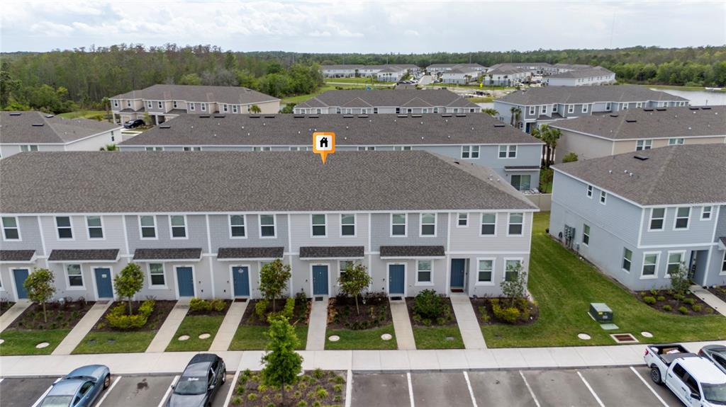 An aerial view shows a row of multi-story townhouses with gray siding and parking spaces — 2060 VIEWFINDER STREET, KISSIMMEE, FL