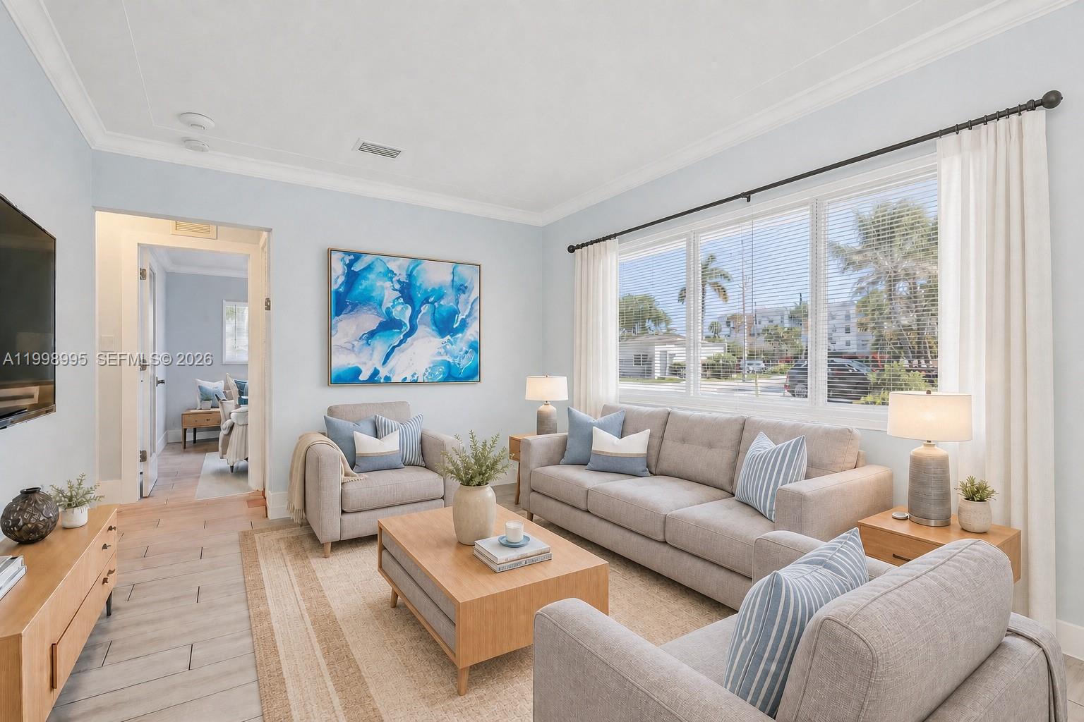 A living room features light gray furniture, a wooden coffee table, and a large window — 1682 NE 124th Ln, North Miami FL 33181, NORTH MIAMI, FL