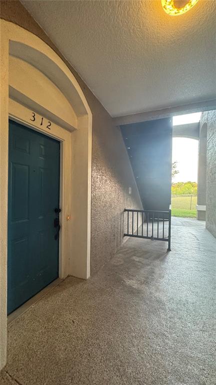 A blue front door labeled 312 opens onto a concrete walkway near an outdoor staircase — 7123 YACHT BASIN AVENUE UNIT 312, ORLANDO, FL