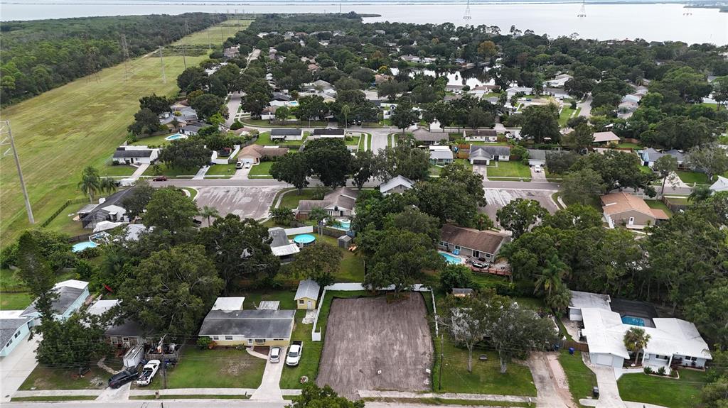 An aerial view shows a residential neighborhood with a cleared, vacant lot in the foreground — 436 COUNTRY CLUB DRIVE, OLDSMAR, FL