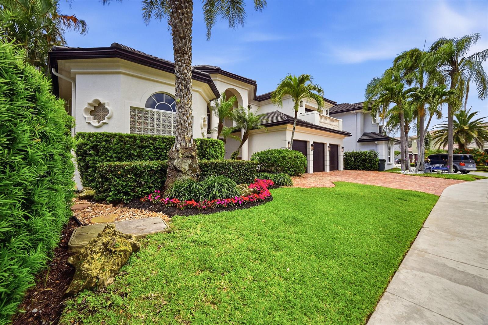 A two-story house with a brick driveway, palm trees, and manicured landscaping — 2425 NW 49th Lane, Boca Raton FL 33431, BOCA RATON, FL