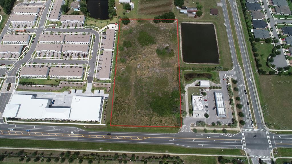 An aerial view shows a rectangular vacant lot outlined in red next to commercial buildings — HICKORY TREE ROAD, ST CLOUD, FL