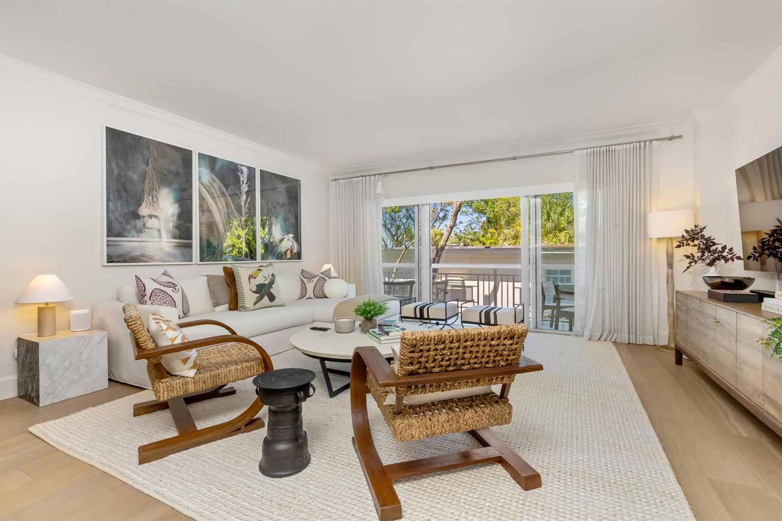 A bright living room features a white sofa, two woven chairs, and a large area rug — 250 Bradley Place # 307, Palm Beach FL 33480, PALM BEACH, FL