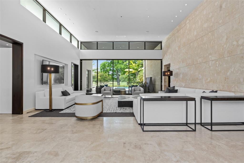 A modern living room features a stone accent wall, white sofas, and large glass doors — 2200 DORADO BEACH DR UNIT 3, DORADO, PR