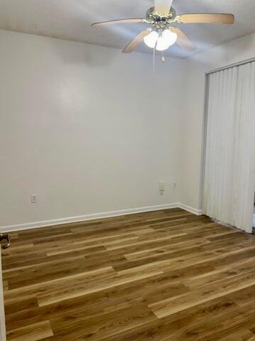An empty bedroom with light-colored walls, wood-look flooring, and a ceiling fan — 4736 Chancellor Drive # 13, Jupiter FL 33458, JUPITER, FL