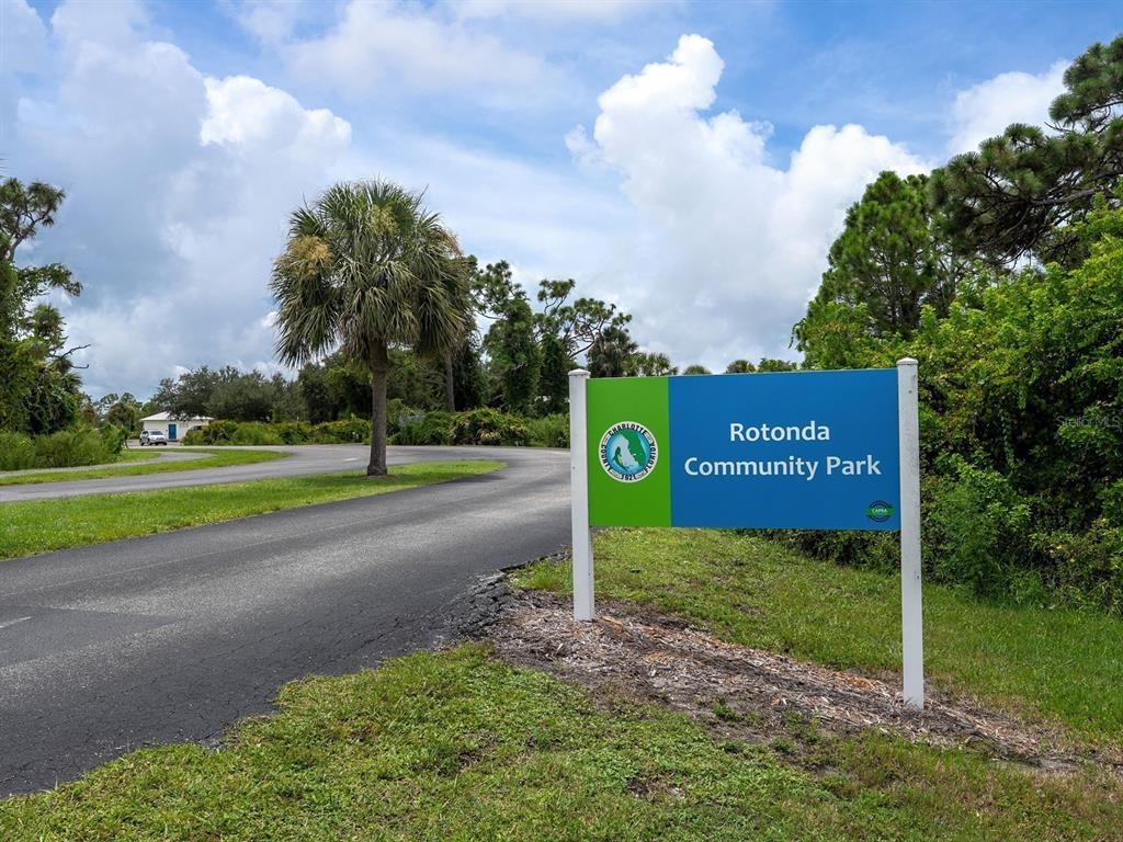 A sign for Rotonda Community Park stands beside a paved road near trees and grass — 104 ARROW LANE, ROTONDA WEST, FL