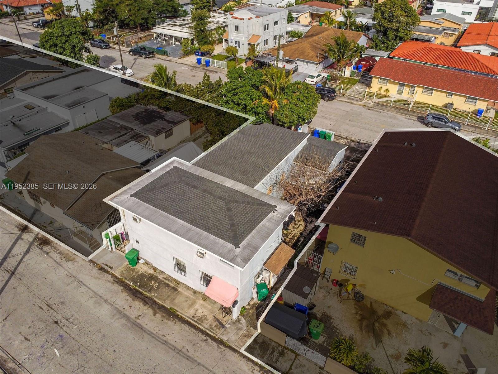 An aerial view shows a white building with a dark roof next to a yellow house — 2105 NW 1st St, Miami FL 33125, MIAMI, FL