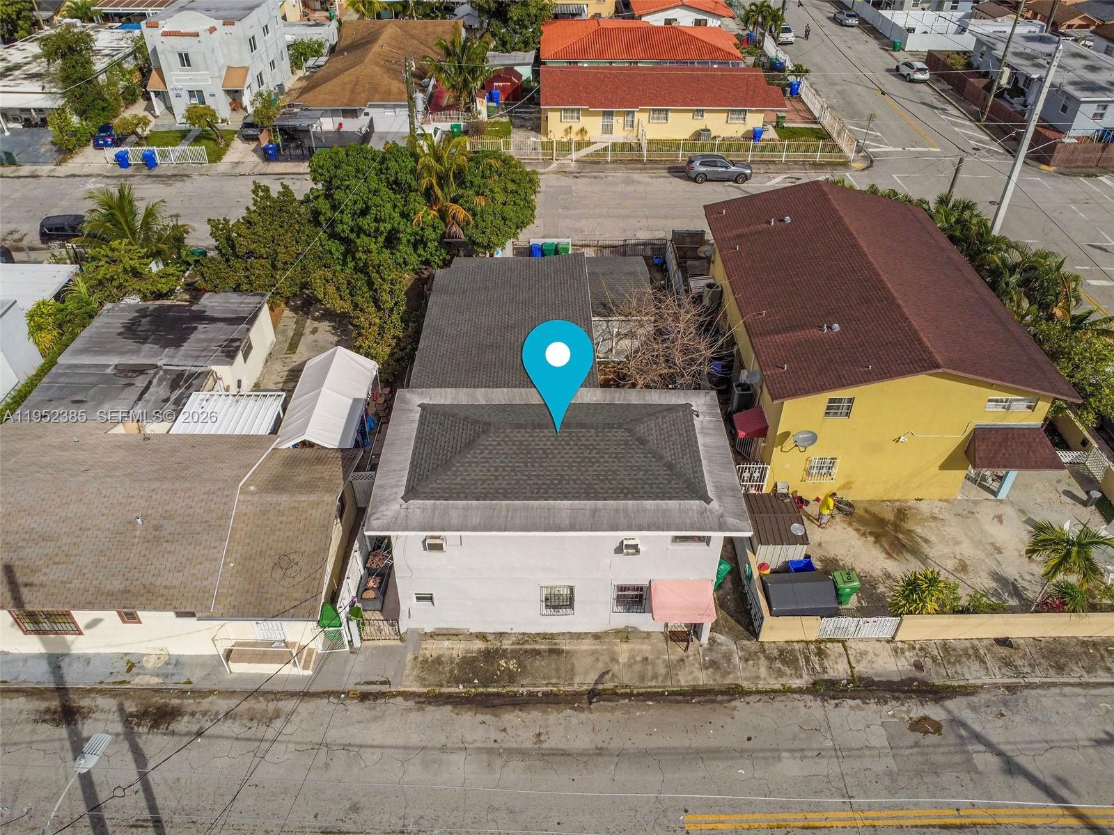 An aerial view shows a two-story house with a gray roof and a blue location pin — 2105 NW 1st St, Miami FL 33125, MIAMI, FL