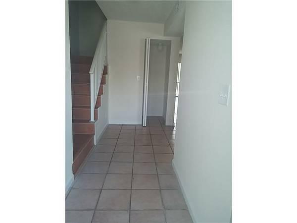 A tiled entryway features a staircase with a white railing and a nearby closet door — 1307 Partridge # 67, Pompano Beach FL 33064, POMPANO BEACH, FL