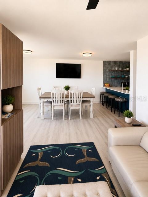 An open-concept living and dining area features a dark patterned rug and a kitchen island — 67 AQUAMARINA UNIT Jobos, ISABELA, PR