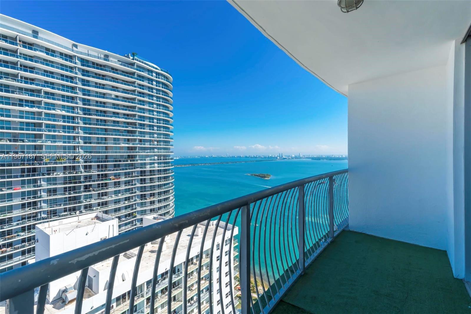 A balcony with a metal railing overlooks a large body of water and high-rise buildings — 1750 N Bayshore Dr # 4507, Miami FL 33132, MIAMI, FL