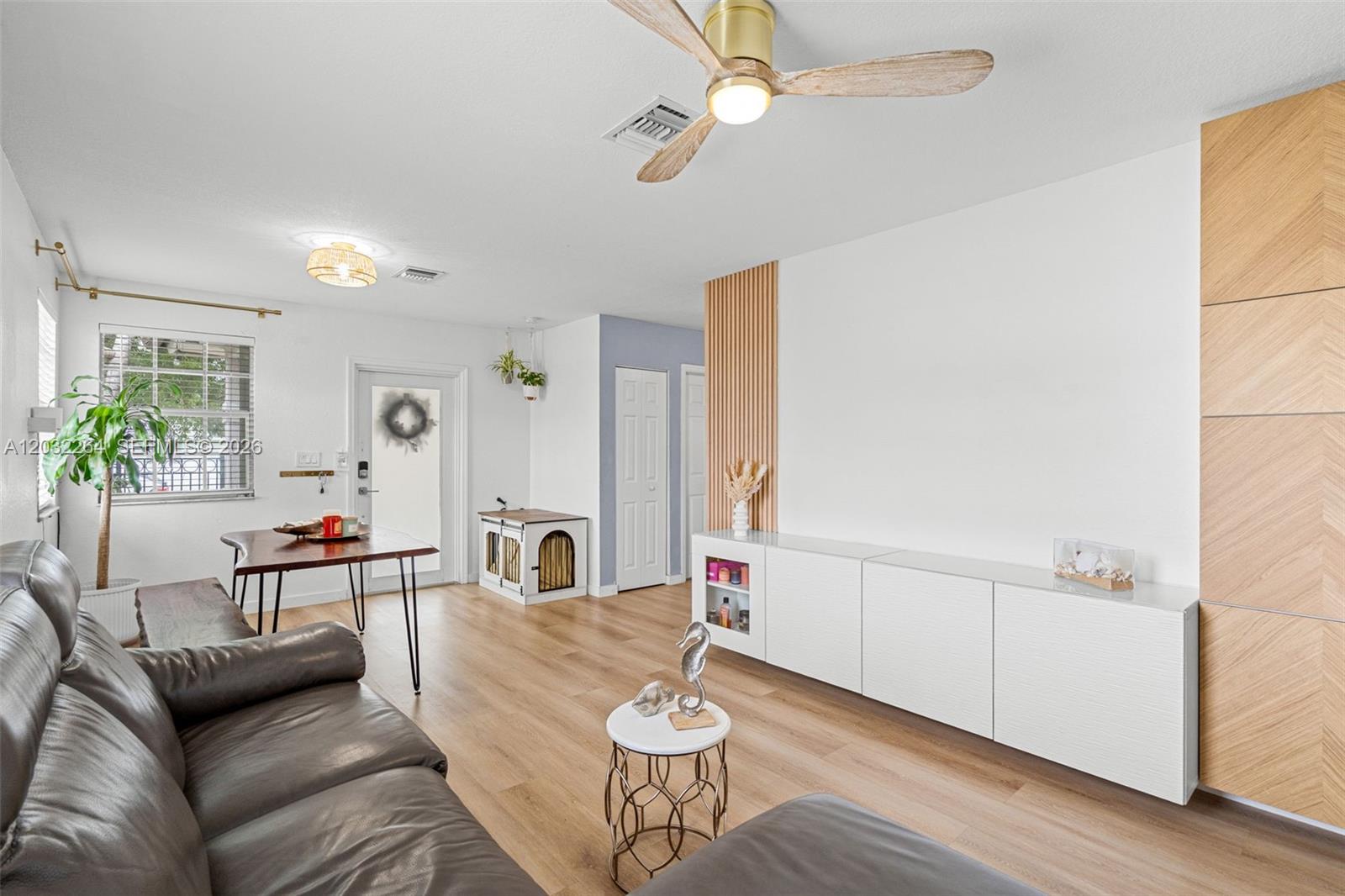 A living room features light wood flooring, a white media console, and a ceiling fan — 1430 NW 5th Ave, Florida City FL 33034, FLORIDA CITY, FL