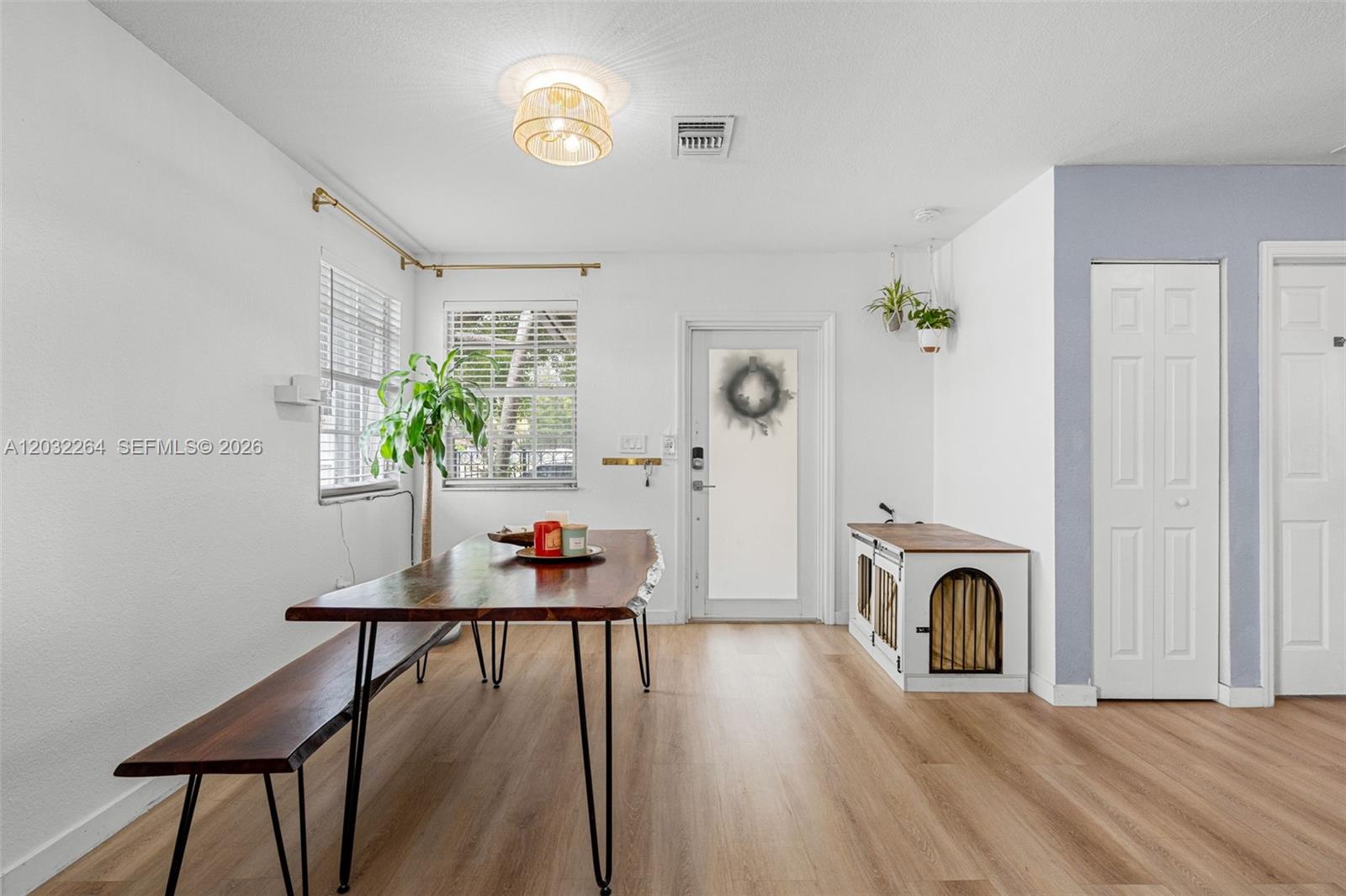 A dining area features a wooden table, bench seating, and a dog crate console — 1430 NW 5th Ave, Florida City FL 33034, FLORIDA CITY, FL