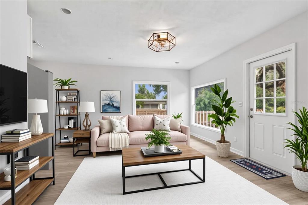 A living room features a pink sofa, wood-frame coffee table, and light wood flooring — 1362 MILTON STREET, CLEARWATER, FL