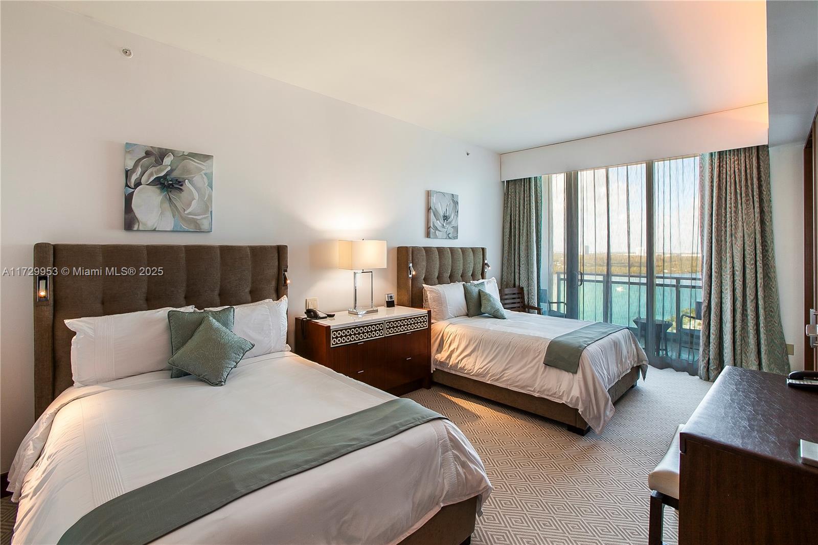 A hotel bedroom features two beds, a nightstand, and a balcony overlooking the water — 10295 Collins Ave # 1612, Bal Harbour FL 33154, BAL HARBOUR, FL